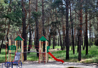 Fototapeta na wymiar A playground for children to play in the forest. A sunny day in the woods in summer .