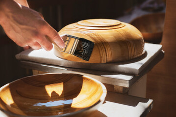 The young man has a new hobby - carves various products from a tree, for example plates for fruit...