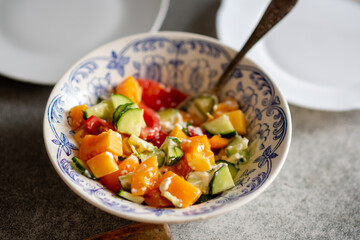 Cucumber and tomato salad with sour cream at a regular kitchen stop at home.