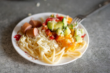 Homemade pasta with cheese and salad on a plate.