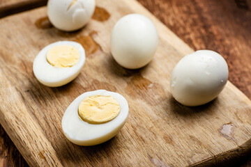 Halves of boiled chicken eggs on a wooden background.