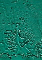 Water drops, streaks on the glass on a green background