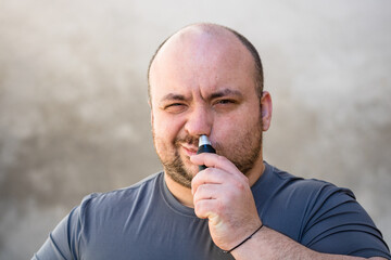 Male shaving ortrimming his nose hair using a hair clipper or electric razor