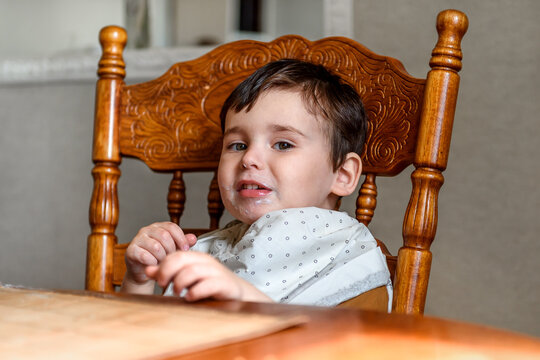 little boy at the table face in food