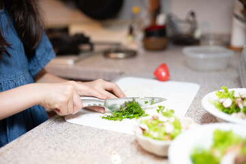 Obraz na płótnie Canvas 自宅でサラダを作る子供の手