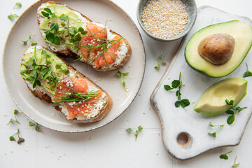 Sandwiches with salted salmon,  avocado and microgreens.