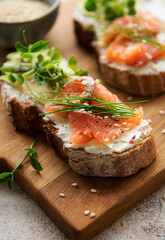 Sandwiches with salted salmon,  avocado and microgreens.
