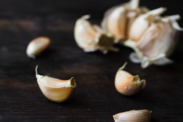 Garlic cloves on a dark wooden table.