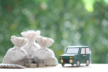 Finance, Model car and money bag on natural green background,Business investment and save money for...