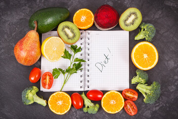 Notepad and fruits with vegetables containing natural vitamins and minerals, slimming and diet concept