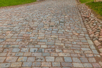 Beautiful view of pavement in park lined with old cobblestones. Sweden.