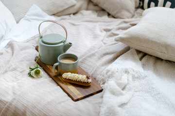 Fototapeta na wymiar Teapot with coffee close to dessert on cutting board