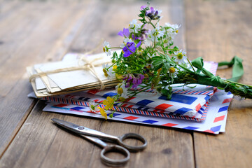 old photographs, envelopes from letters, wild flowers bouquet on table, home archive documents,...