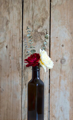 Rosas en una botella. Fondo de madera