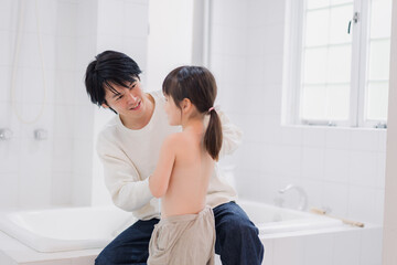 お風呂で娘の体を拭くお父さん