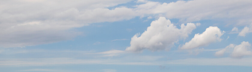 Banner with white fluffy clouds on a light blue sky background