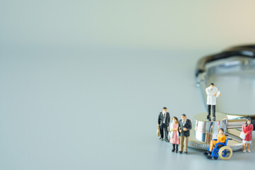 selective focus of miniature doctor on black stethoscope and miniature people with mask on white ground to solution for Annual Health Check up.
