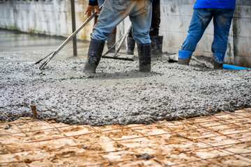 Construction workers are pouring concrete pavement at the construction site.