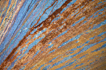 Abstraktier Verlauf von Rost in Form von Streifen auf einer grau-blauen Oberfläche als Metall