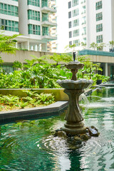 Fountain in the pond of residential building inner garden