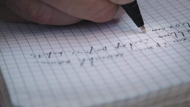 Close-up of a pen writing. A person makes notes in a notebook with a ballpoint pen. Fake "Lorem Ipsum" text. Camera is following the pen. Close-up macro. Shallow depth of field.