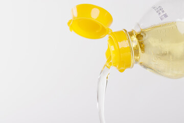 Vegetable oil pouring on white background. palm oil pouring from plastic bottle.