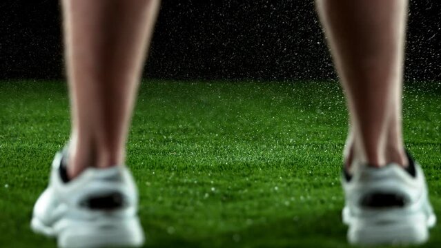 Super slow motion of hitting golfball in detail. Man legs with shoes blurred on foreground. Filmed on high speed cinema camera, 1000fps.