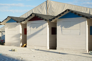Naklejka premium white houses located on the beach waiting for traders to open them.