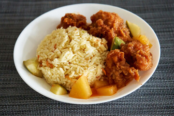 A plate of fried rice and fried chicken. Asian cuisine