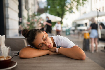 Bored, indifferent girl at a table in a street cafe