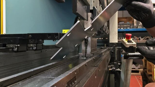 Bending sheet metal with a hydraulic bending machine at the factory.