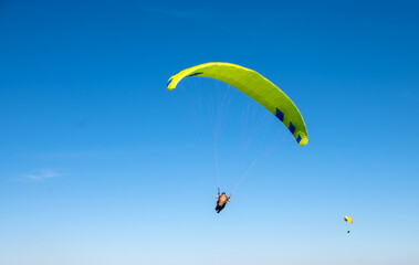 The sportsman flying on a paraglider. Silhouette on blue sky.
Paragliding take off. Travel...