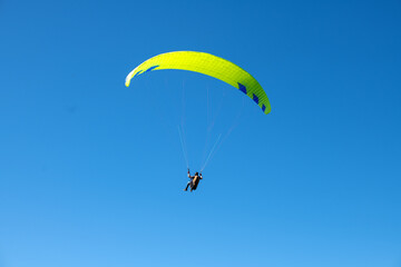 The sportsman flying on a paraglider. Silhouette on blue sky.
Paragliding take off. Travel...