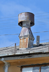 Exhaust ventilation on the roof of an old building on a summer day