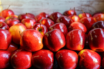 Many bright red apples placed in a container and stacked.