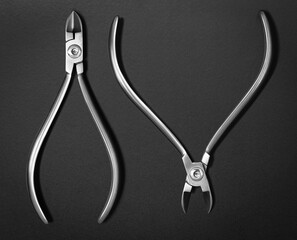 Set of dental metal instruments for treating and checking teeth. Top view on black background