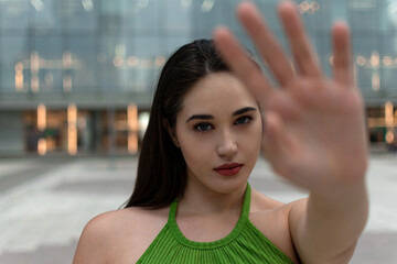 Woman with her hand extended signaling to stop - her face is in focus