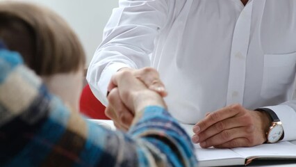 The bank manager shakes hands with the client. Salesman-banker-manager shaking hands with the client