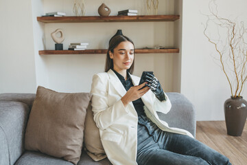 A woman with a bionic prosthetic arm holds a mobile phone in her hands, communicates on social...
