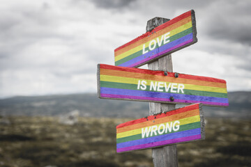 love is never wrong text quote on wooden signpost crossroad outdoors in nature. Freedom and lgbtq community concept.