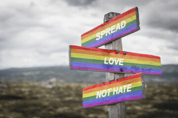 spread love not hate text quote on wooden signpost crossroad outdoors in nature. Freedom and lgbtq community concept. - obrazy, fototapety, plakaty