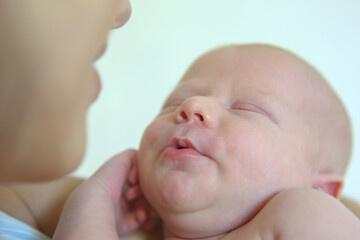 Portrait of a sleeping newborn baby with a mother close-up