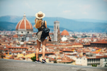 Young attractive smiling girl tourist in hat exploring new Europe city at summer holiday at Florence - obrazy, fototapety, plakaty