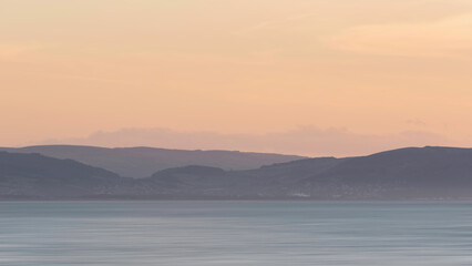 Stunning landscape image of pastel color sunset over ocean giving lovely soft dreamy relaxing feel