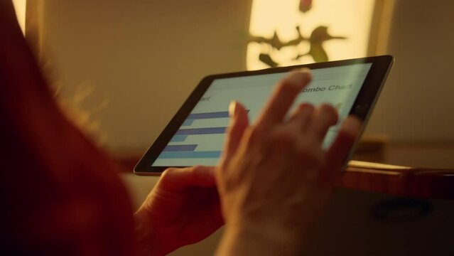 Corporate manager browsing tablet charts on airplane. Hands touching pad closeup