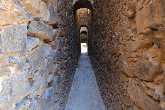 Image a narrow corridor between some stone walls in the cemetery