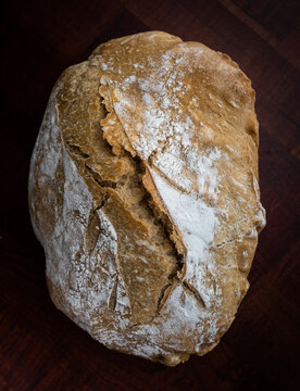 Loaf of bread on a dark wood board