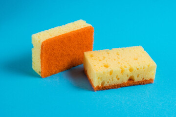 Yellow porous sponges for cleaning on a blue background with copy space. Home cleaning concept