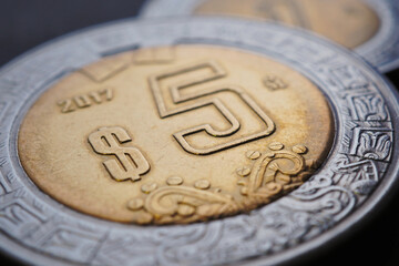 Coin of 5 Mexican pesos closeup. Peso of Mexico. News about economy or currency. Loan and credit. Money and taxes. Focus on peso symbol. Macro