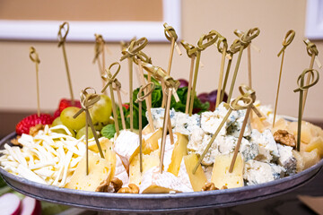 Appetizer plate: strawberry canapé, Cecil cheese, blue mold cheese, grapes, walnuts, honey, mint leaves, skewers. Catering serving.